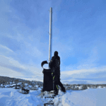 Installatør monterer rustfrie stålrør inne i en gammel skorstei