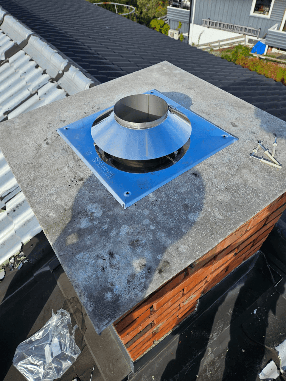 rosessen med å installere et stålrør i en mursteinskorstein, med et forberedt hull på toppen.