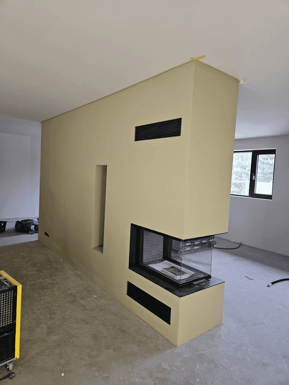 en moderne peisinnbygging med ventilasjonssystem, rektangulært design i et lyst rom under sluttføring.