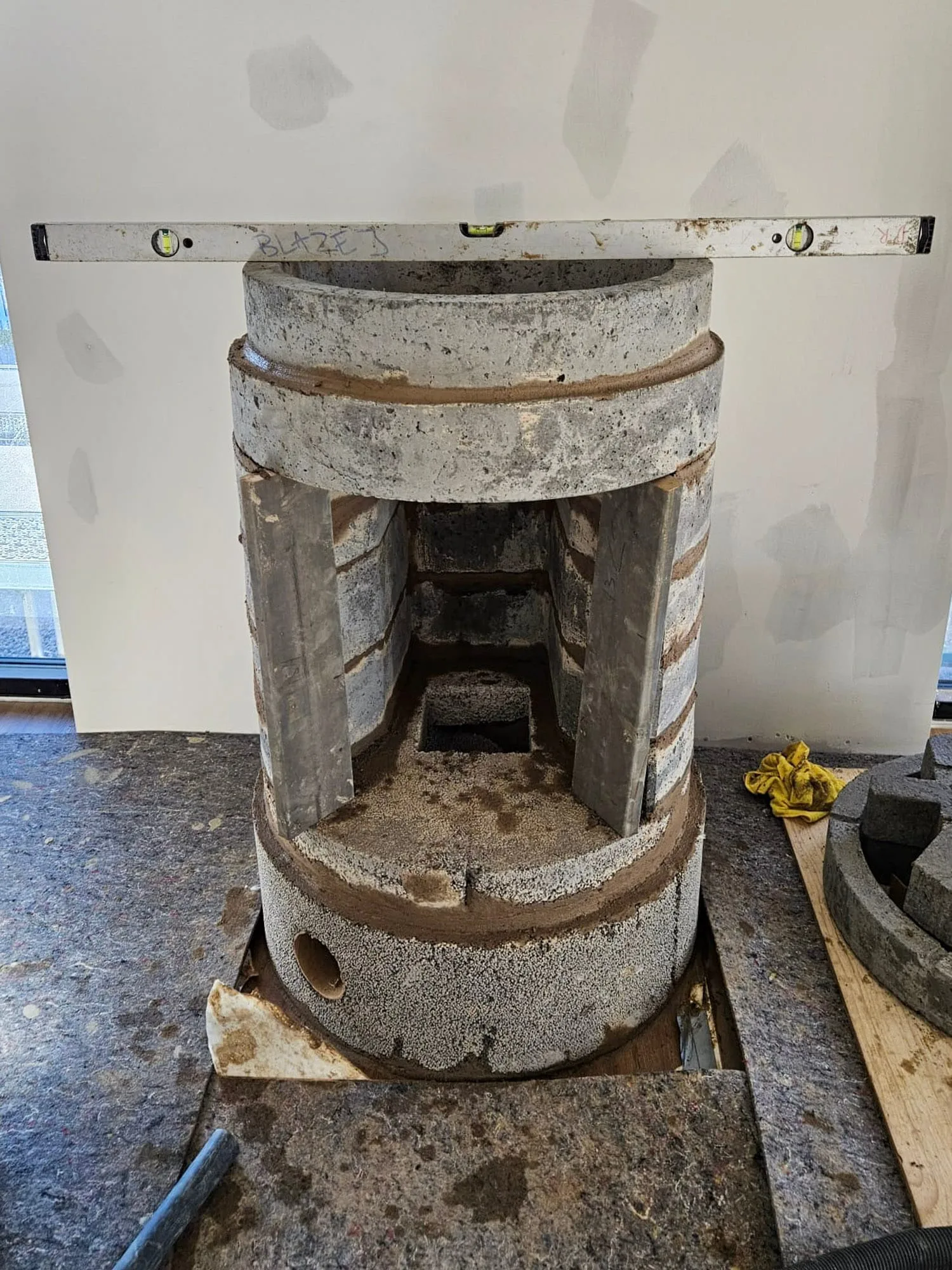 Bygging av kakkelovn, en prosess som krever nøyaktighet og erfaring for optimal varmelagring.